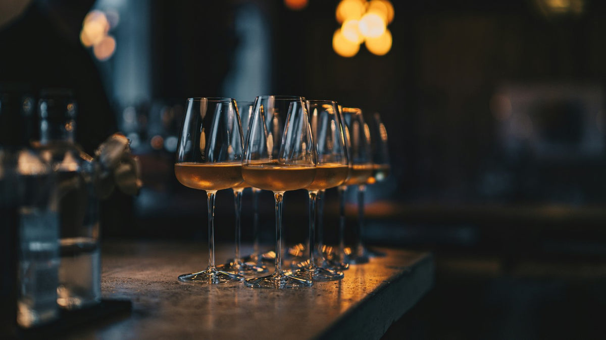 White wine glasses on a bar in warm light