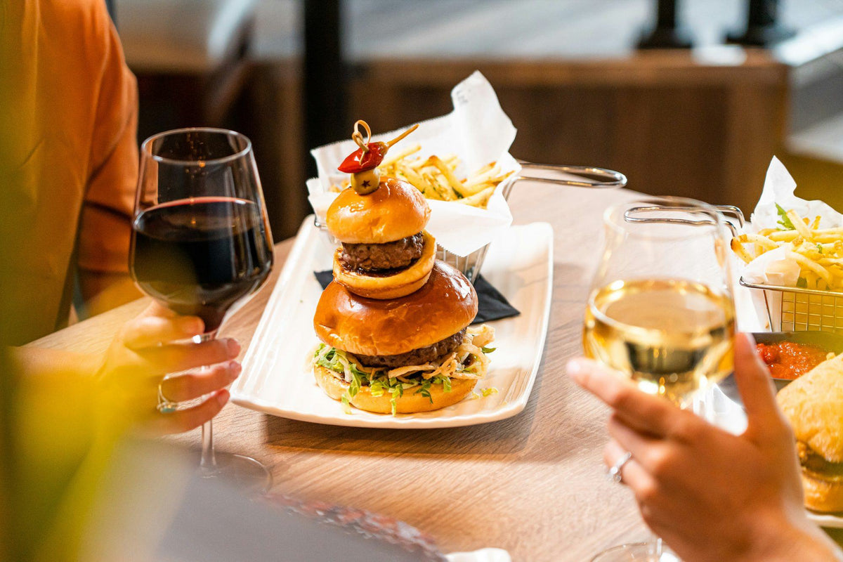 Burger served with a glass of red wine and a glass of white wine