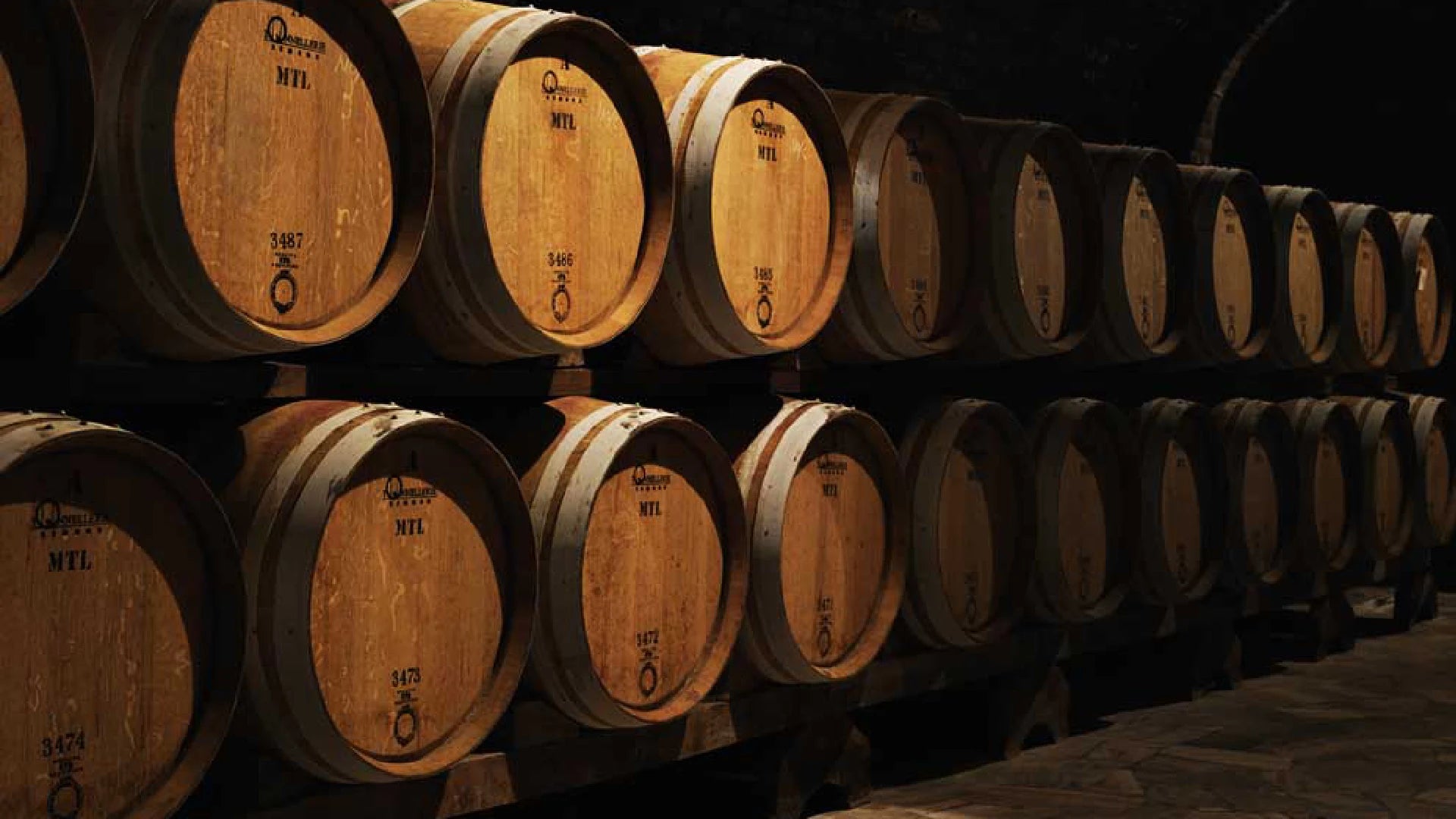  Félsina cellar with neatly stacked wooden barrels, highlighting traditional winemaking and a rustic, aged atmosphere.