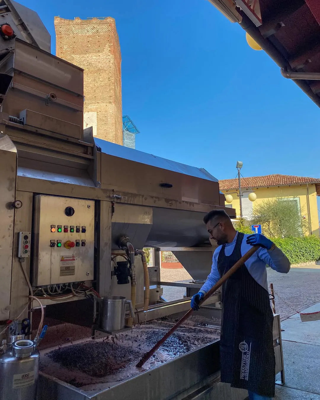 Winemaker stirring fermenting grapes during the production process at Produttori del Barbaresco.
